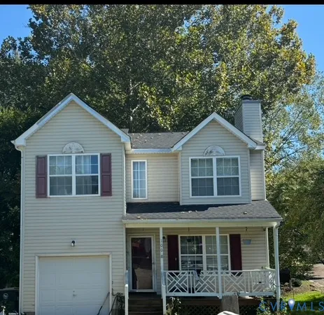 a front view of a house with a yard and trees