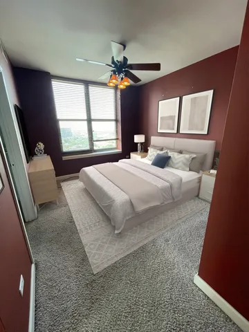 a bedroom with a bed a dresser next to a window