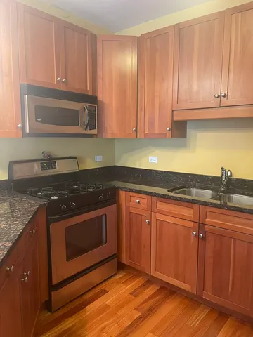a kitchen with granite countertop cabinets stainless steel appliances and a sink