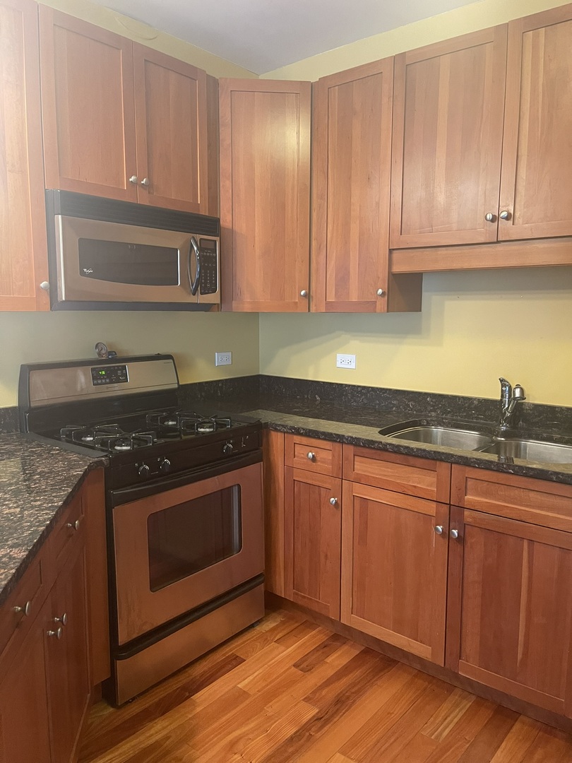 1101 South State Street, Unit 2104 Chicago, IL 60605 - Photo 2 of 37 a kitchen with granite countertop cabinets stainless steel appliances and a sink