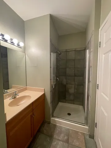 a bathroom with a shower a sink and mirror