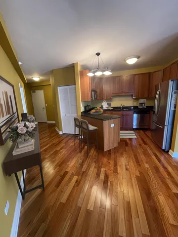 a kitchen with a sink appliances and wooden floor