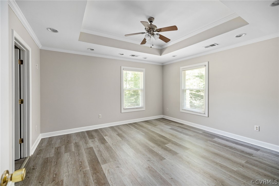1305 Eastham Road Bumpass, VA 23024 - Photo 25 of 49 Empty room featuring a tray ceiling, light hardwoo