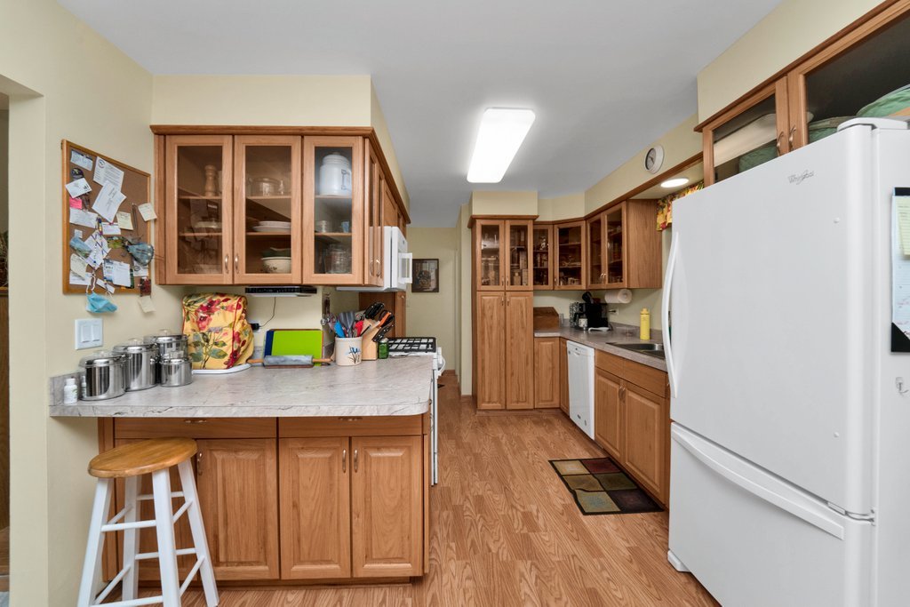 16 Tweed Road Fox Lake, IL 60020 - Photo 9 of 27 a kitchen with a refrigerator a sink and wooden cabinets
