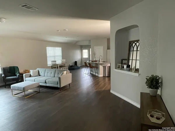 a living room with furniture and wooden floor