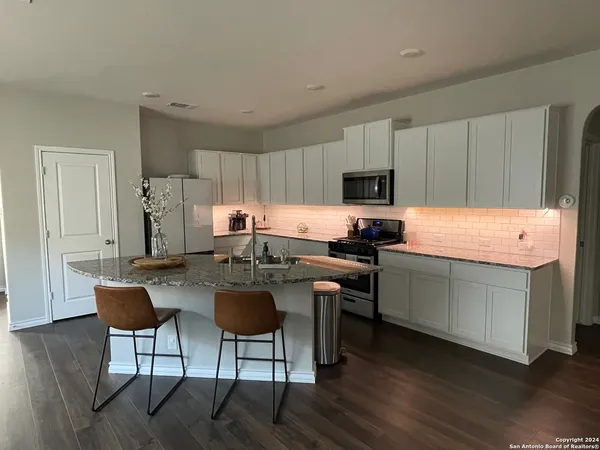 a kitchen with a refrigerator stove top oven and sink