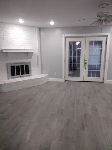 an empty room with windows and fireplace