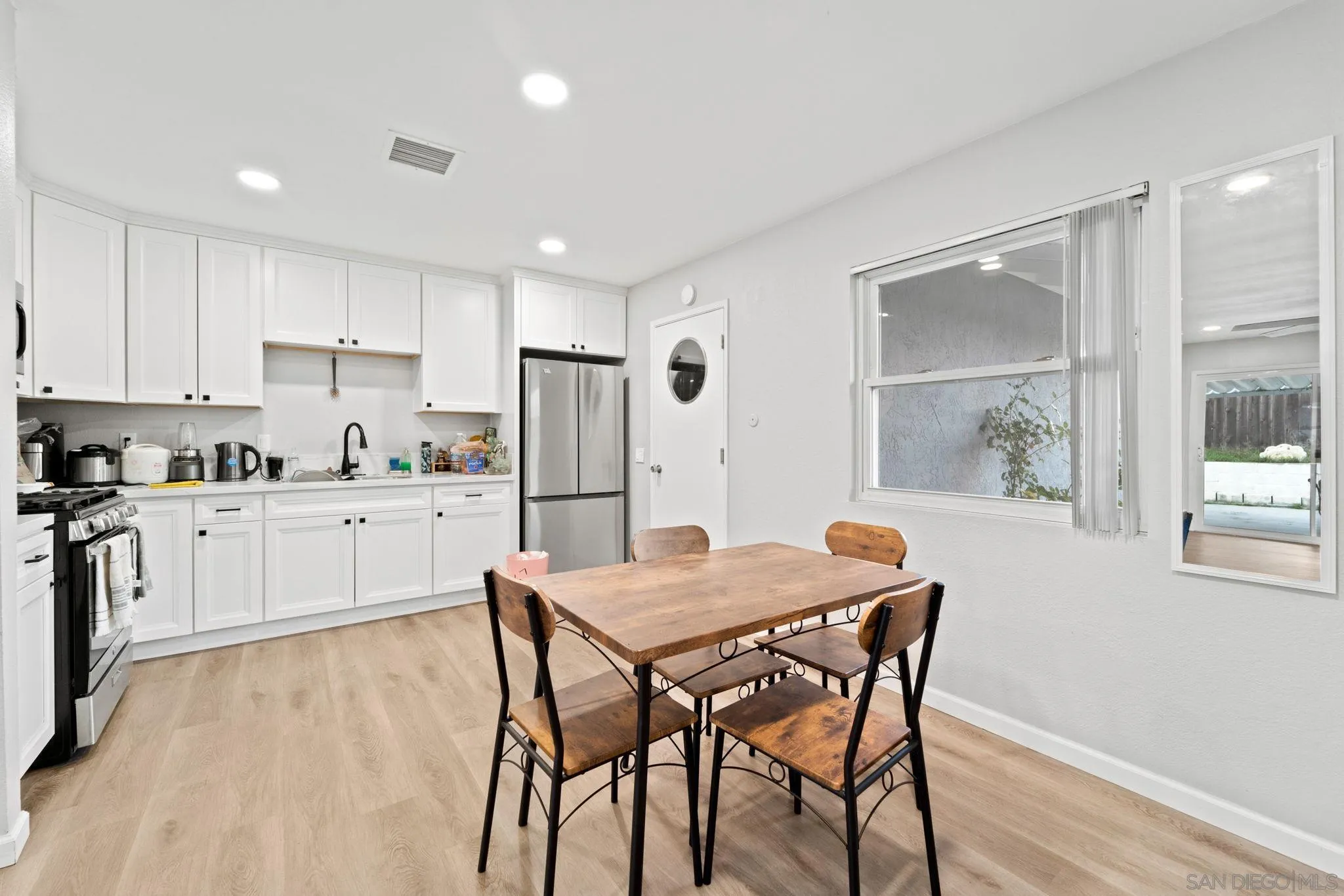 337 Osage Street Spring Valley, CA 91977 - Photo 4 of 19 a kitchen with stainless steel appliances a white table chairs and a refrigerator