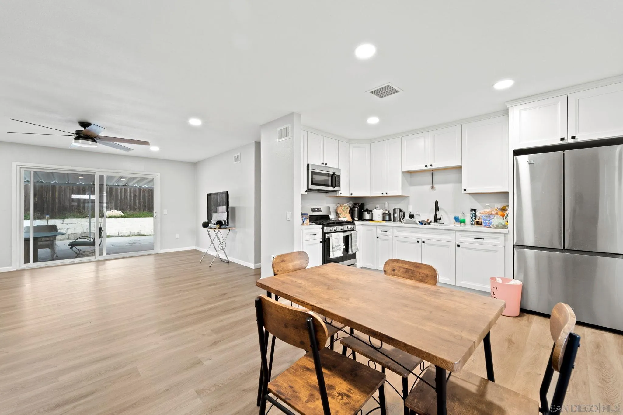 337 Osage Street Spring Valley, CA 91977 - Photo 8 of 19 a kitchen with a dining table chairs refrigerator and cabinets