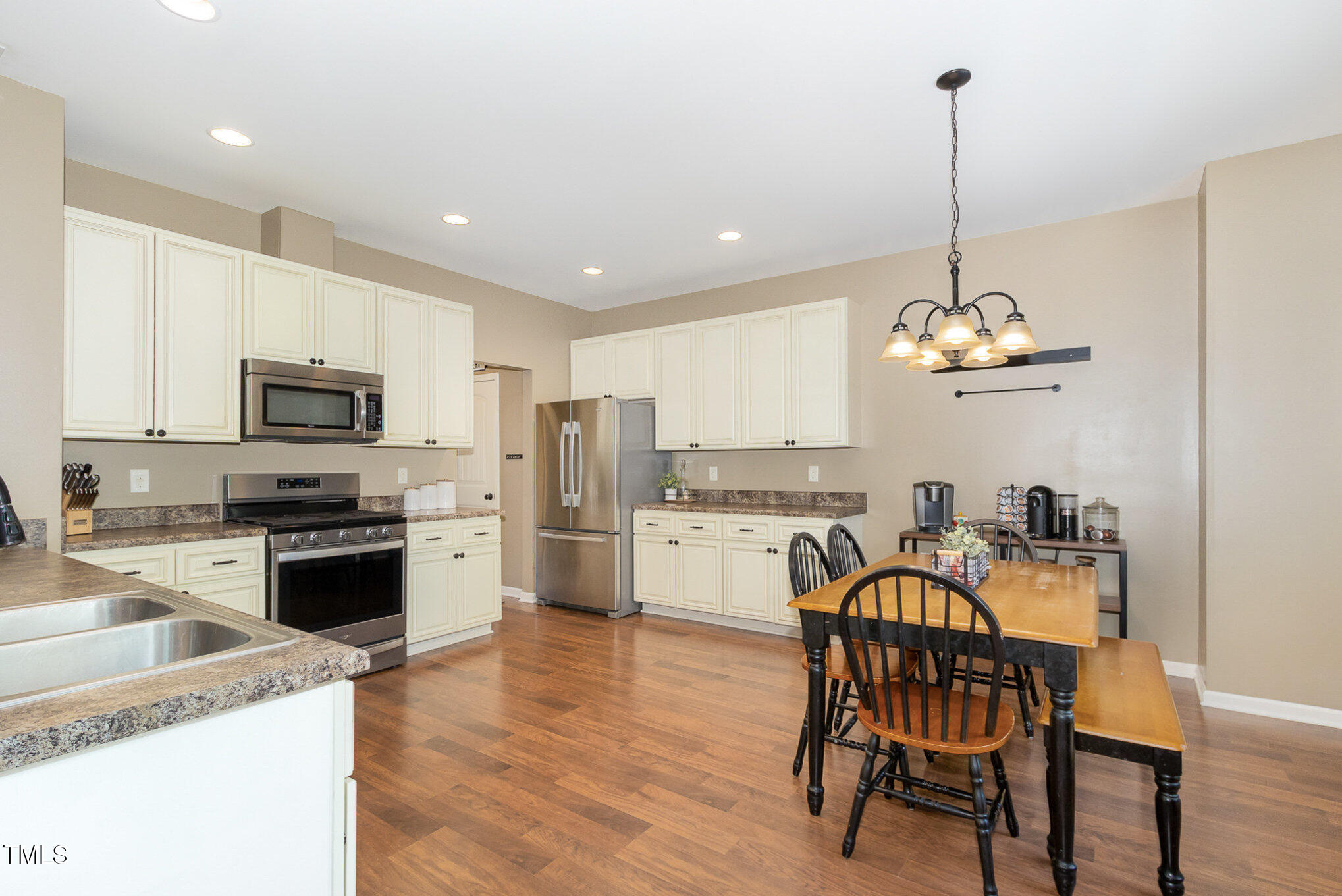 118 Truss Way Durham, NC 27704 - Photo 11 of 27 a open kitchen with stainless steel appliances granite countertop a stove top oven a refrigerator a sink with a dining table and chairs