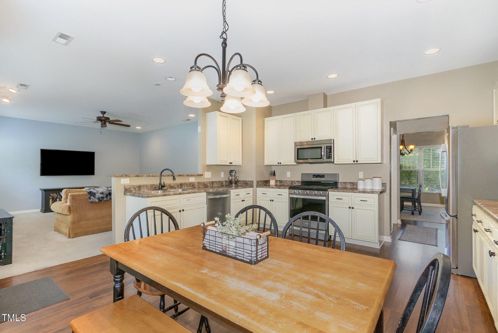 118 Truss Way Durham, NC 27704 - Photo 15 of 27 a kitchen with stainless steel appliances granite countertop a stove top oven a sink a dining table and chairs with wooden floor