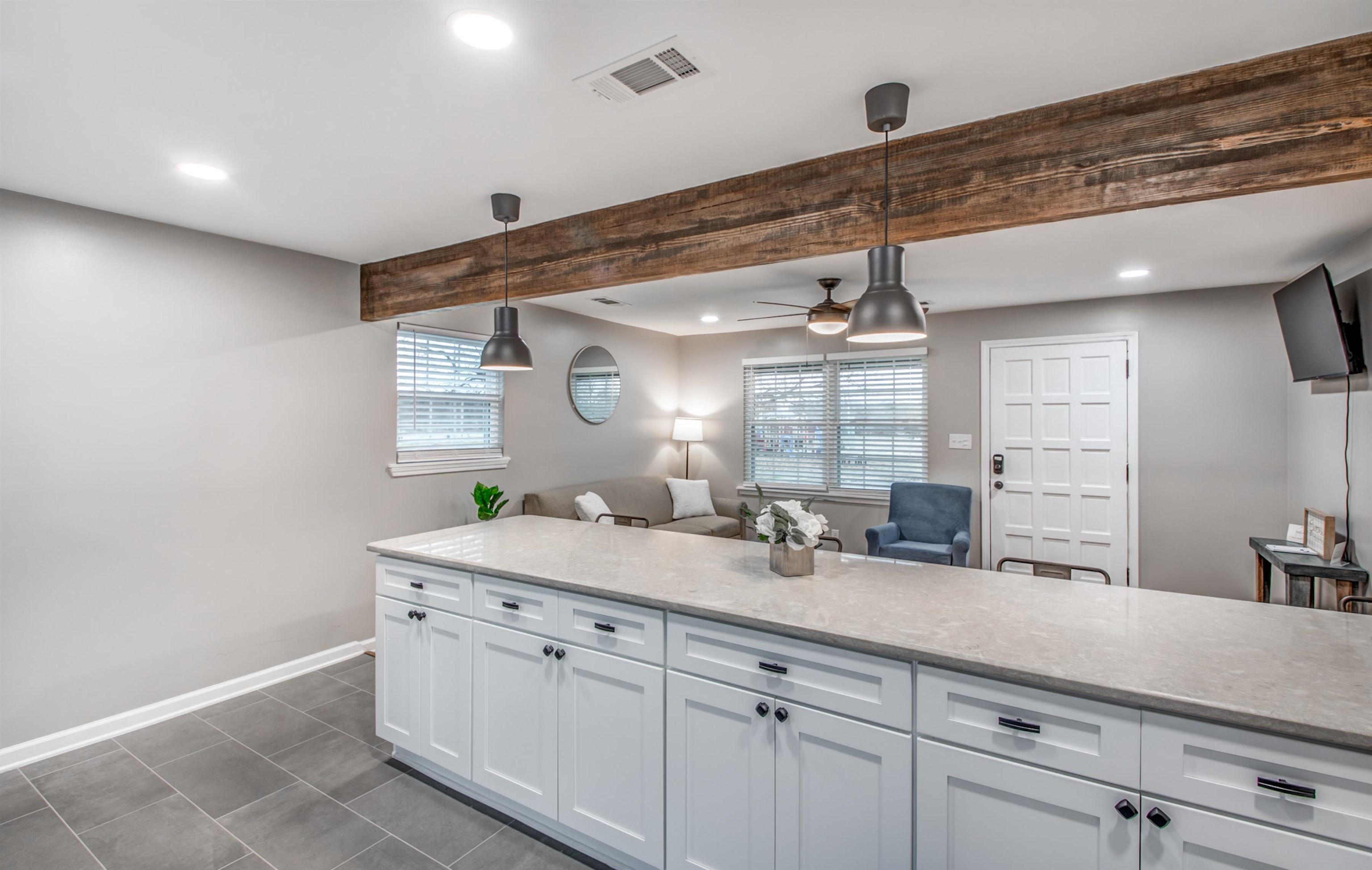 1277 Wellsville Road Memphis, TN 38117 - Photo 18 of 39 Kitchen with light stone counters, ceiling fan, pendant lighting, and beamed ceiling
