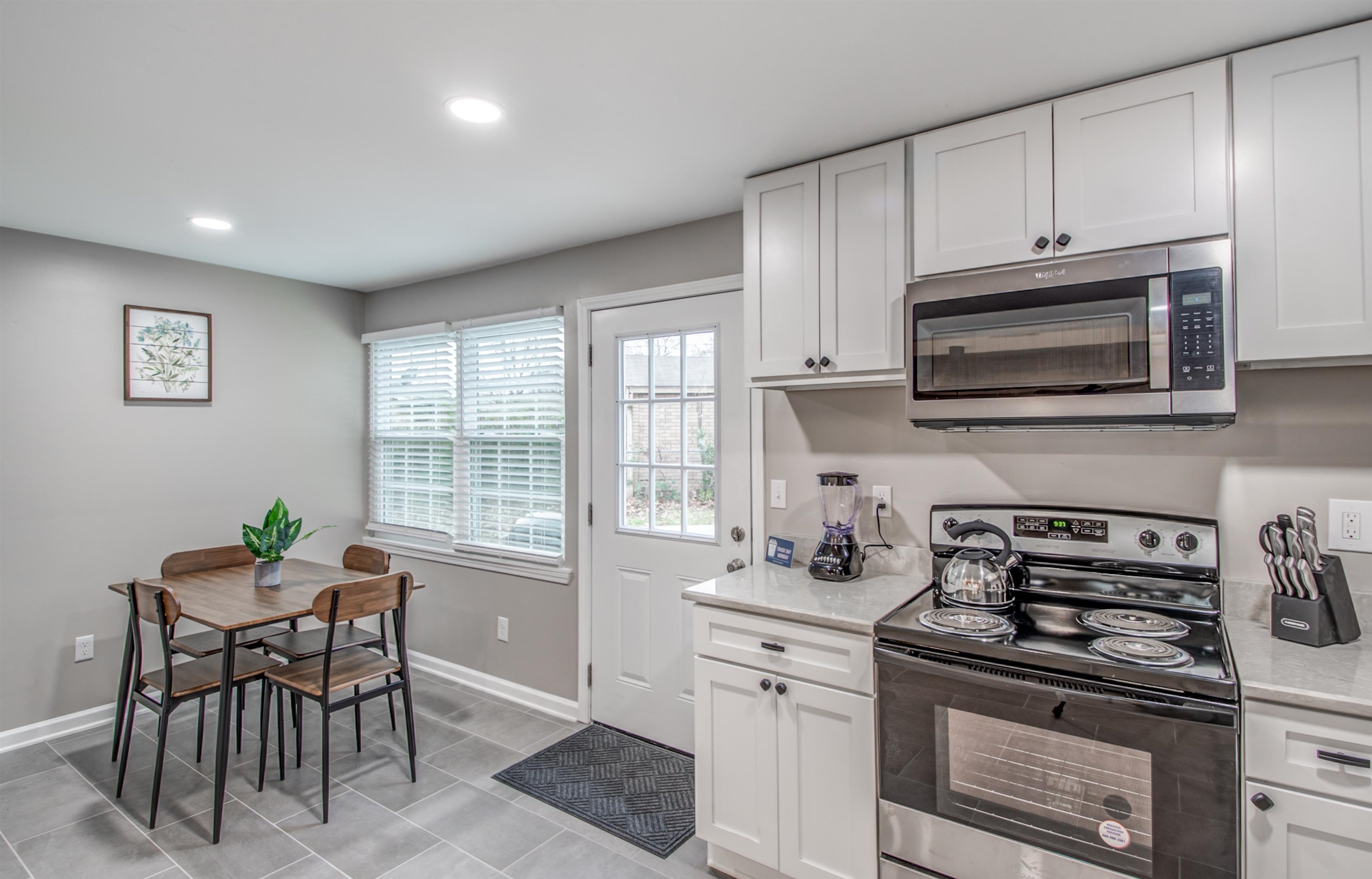 1277 Wellsville Road Memphis, TN 38117 - Photo 21 of 39 a kitchen with stainless steel appliances a stove a sink cabinets and a window