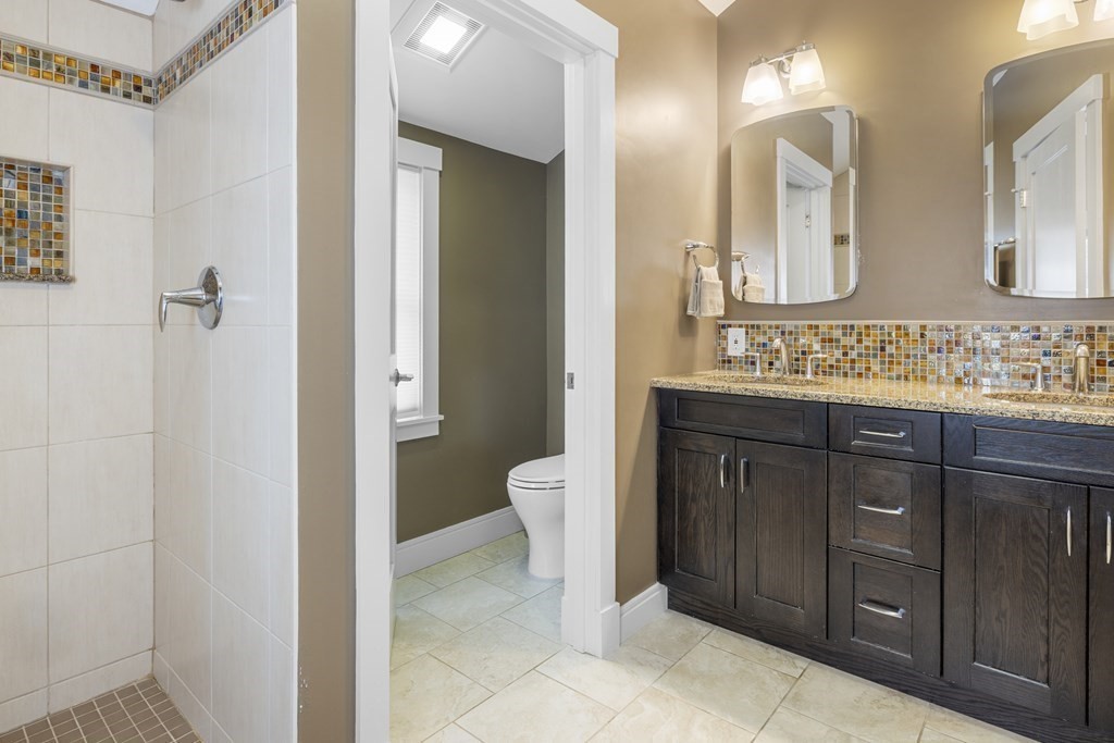 20 Richard Road Lexington, MA 02421 - Photo 16 of 28 a bathroom with a double vanity sink a toilet and a mirror