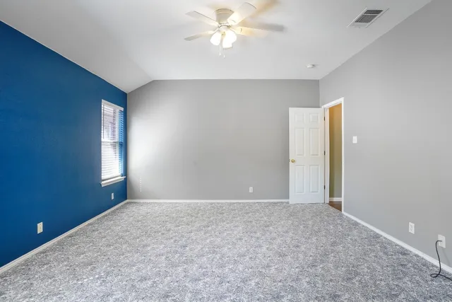 an empty room with closet and a chandelier fan