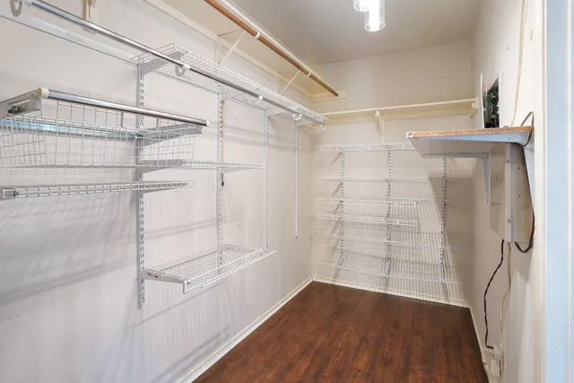 a view of walk in closet with wooden floor