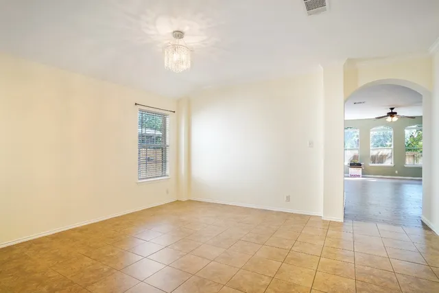 an empty room with kitchen view and a window