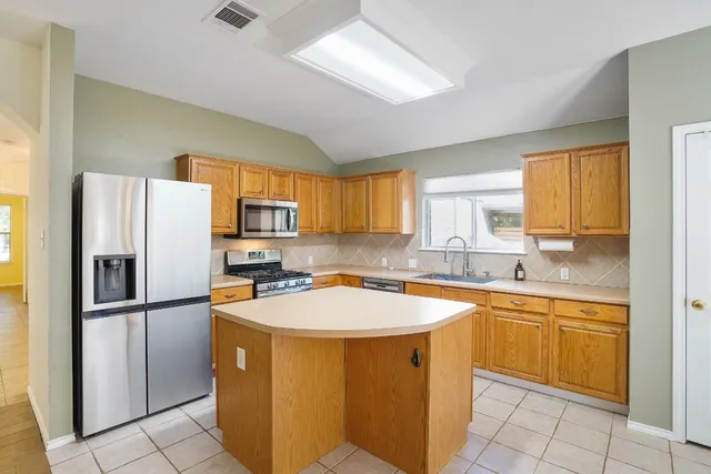 a kitchen with stainless steel appliances granite countertop a refrigerator and a sink