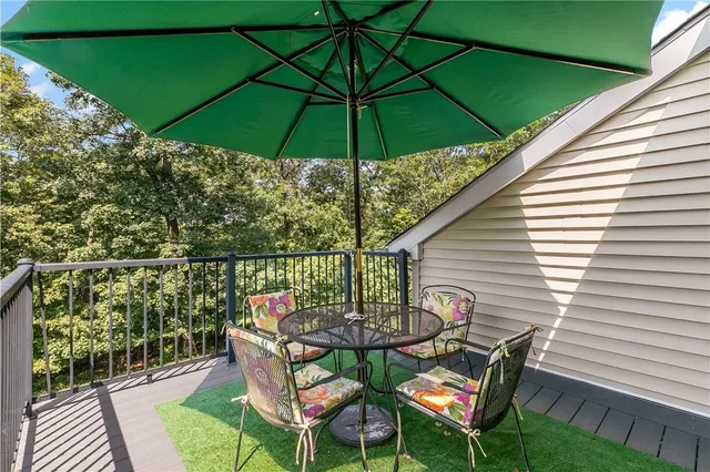 a patio with wooden floor a yard a table and chairs