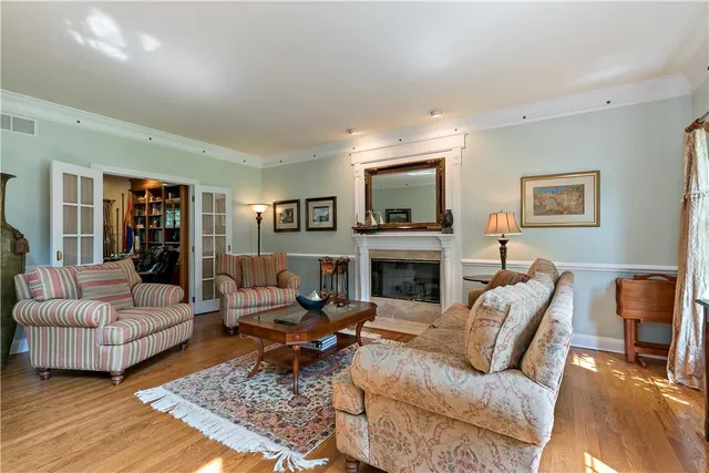 a living room with furniture a rug a fireplace and a large window