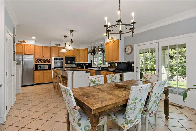 a view of a dining room and livingroom with furniture wooden floor a chandelier