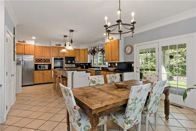 a view of a dining room and livingroom with furniture wooden floor a chandelier