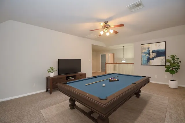 a living room with pool table and a flat screen tv