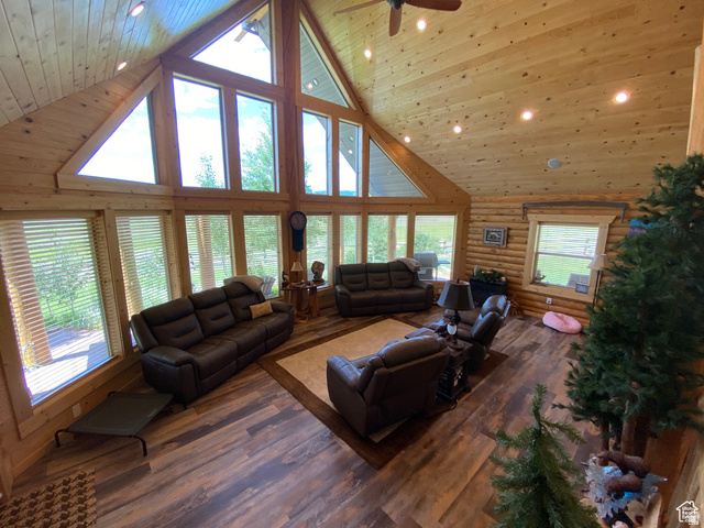 79 Auburn Forest Road Auburn, WY 83111 - Photo 18 of 76 Living area with log walls, hardwood / wood-style floors, recessed lighting, a high wood ceiling, and ceiling fan