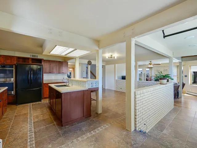 a large kitchen with stainless steel appliances kitchen island granite countertop a large counter top and stove
