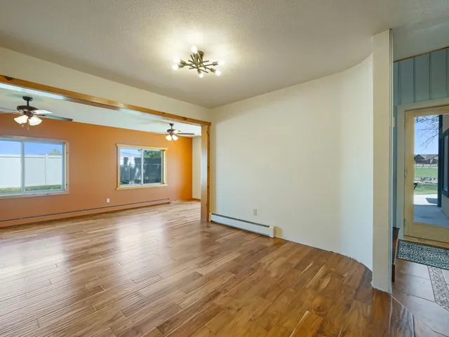 a view of empty room with wooden floor