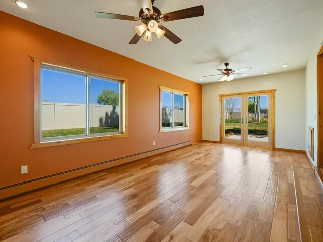 a view of an empty room with a window and wooden floor