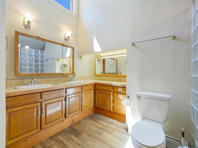 a spacious bathroom with a granite countertop toilet sink and mirror