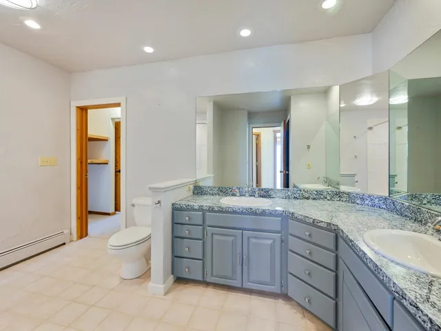 a spacious bathroom with a granite countertop sink toilet and shower