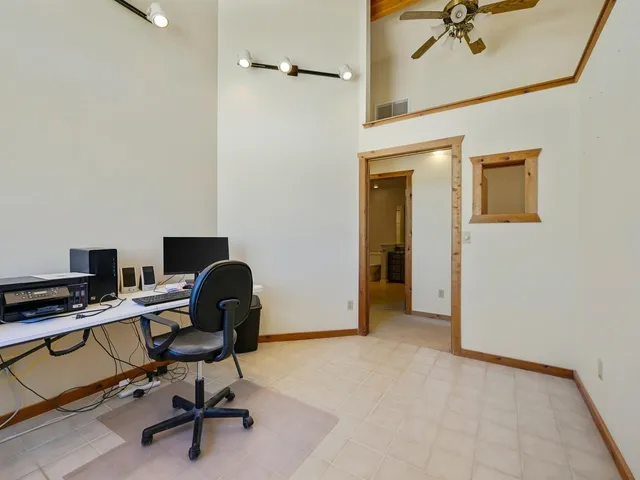 a view of a workspace with furniture and a window