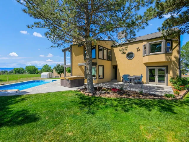 a front view of a house with swimming pool garden and outdoor seating