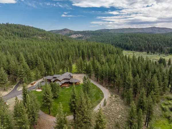 an aerial view of a house with a yard and lake view