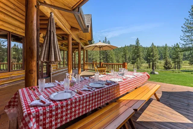 a view of a patio with table and chairs with wooden floor and fence