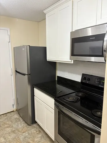 a kitchen with stainless steel appliances a stove a microwave and a refrigerator
