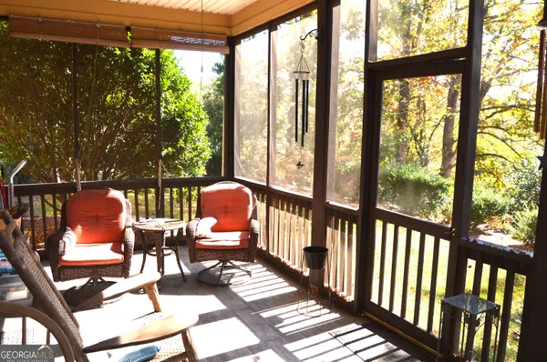 a view of a chairs and table in patio next to a yard