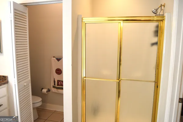a bathroom with a granite countertop shower and a toilet