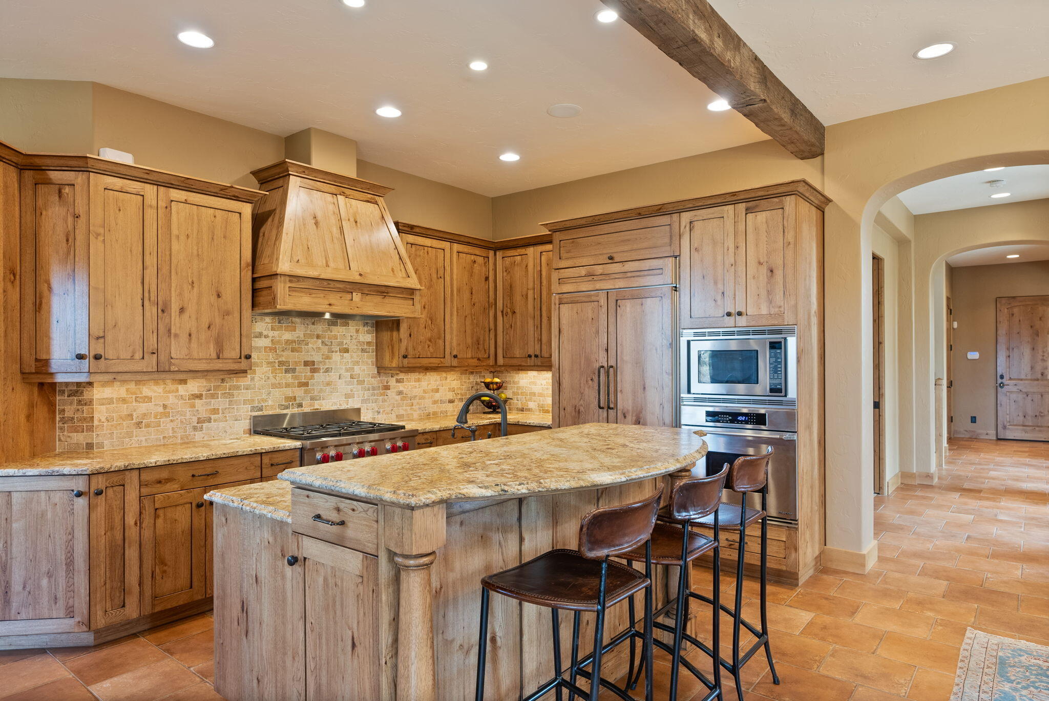 22887 Ghost Tree Lane Bend, OR 97701 - Photo 16 of 97 A chef's kitchen with Wolf gas cooktop, wood paneled SubZero refrigerator, full height tiled backsplash & built-in Miele Coffee maker
