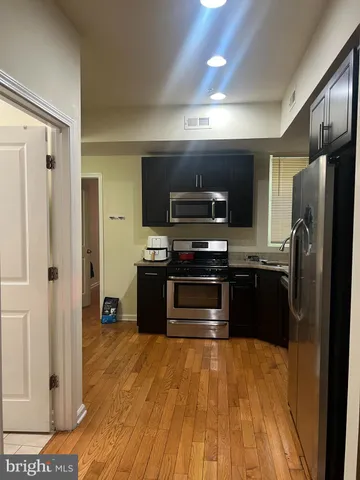 a kitchen with stainless steel appliances a refrigerator and a stove top oven