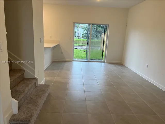 a view of kitchen with granite countertop a sink and a black stove top oven