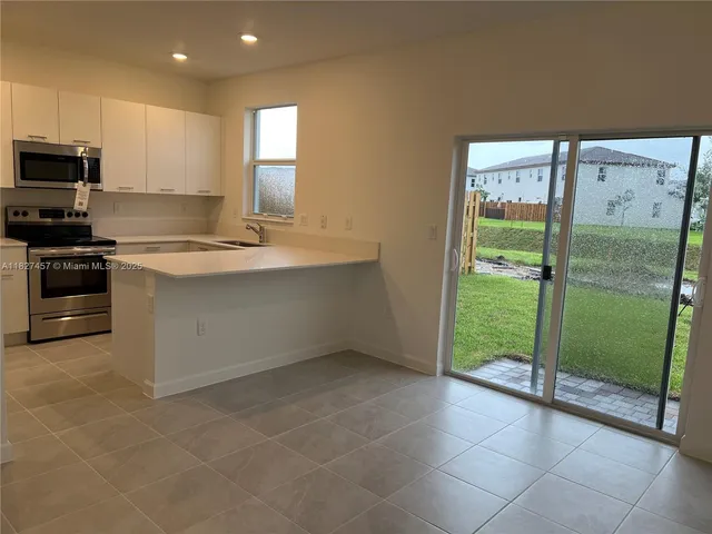a kitchen with kitchen island white cabinets and stainless steel appliances