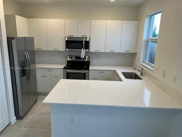 a kitchen with stainless steel appliances a refrigerator and a stove