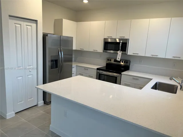 a kitchen with granite countertop a stove a sink and a microwave