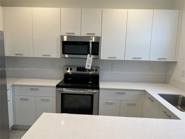 a kitchen with a refrigerator stove and microwave