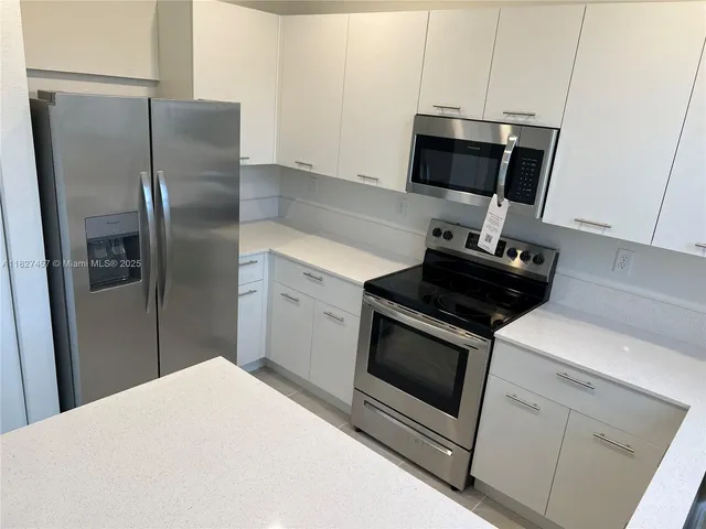 a kitchen with a sink and white cabinets