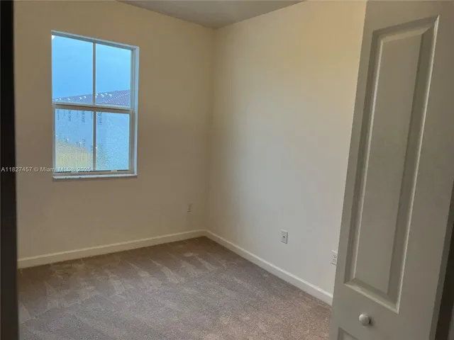 an empty room with closet and a bathroom