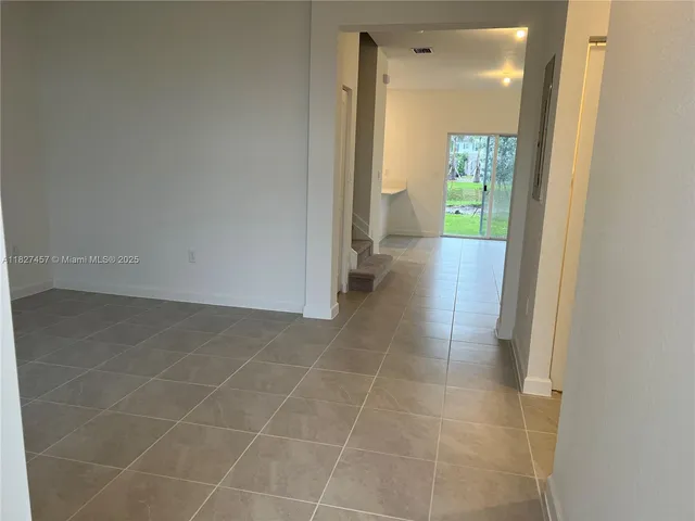 a view of a small space with wooden floor and a window